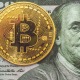Round gold Bitcoin placed on a $100 bill